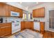 Virtually staged kitchen with wood cabinets at 818 S Terry St # 85, Longmont, CO 80501