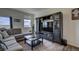 Living room with sectional sofa, large TV, and built-in shelving at 45780 Silverdrop Ave, Bennett, CO 80102