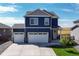Two-story blue house with white two-car garage and landscaping at 45780 Silverdrop Ave, Bennett, CO 80102