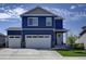 Two-story blue house with white two-car garage and landscaping at 45780 Silverdrop Ave, Bennett, CO 80102