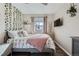 Cozy bedroom featuring a gray bed frame, neutral decor, and a wall of greenery at 3944 Morning Glory Dr, Castle Rock, CO 80109