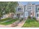 Three-story townhouses with gray siding and landscaping at 10569 W Dartmouth Ave, Lakewood, CO 80227