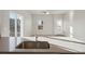 Modern kitchen with a large island, stainless steel sink, and sliding glass doors at 3012 Oxley St, Strasburg, CO 80136