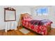 Bedroom with a floral bedspread, mirror, and wood floors at 14605 E 11Th Ave, Aurora, CO 80011