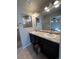 Double vanity bathroom with dark cabinetry and a sizable mirror at 5046 Espana Way, Denver, CO 80249