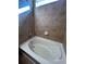Relaxing bathtub with neutral tile and window, perfect for soaking at 5046 Espana Way, Denver, CO 80249