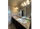 Double vanity bathroom with dark cabinets and a large mirror at 5046 Espana Way, Denver, CO 80249