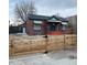 Brick ranch home with striped awnings and a new wood fence at 1453 Chester St, Aurora, CO 80010