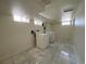 Basement laundry room with washer, dryer, and marble flooring at 1453 Chester St, Aurora, CO 80010
