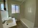 Clean bathroom with a bathtub, sink, and tiled walls at 1453 Chester St, Aurora, CO 80010