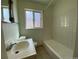 Clean bathroom with a bathtub, sink, and tiled walls at 1453 Chester St, Aurora, CO 80010