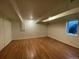 Finished basement room with hardwood floors and large window at 1453 Chester St, Aurora, CO 80010