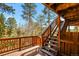 Wooden deck with stairs leading down, offering wooded views at 28730 Mountain View Rd, Conifer, CO 80433