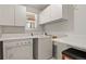 Laundry room with washer, dryer, cabinets, and folding counter at 28730 Mountain View Rd, Conifer, CO 80433