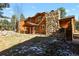 Two-story home with wood siding, stone fireplace, and deck at 28730 Mountain View Rd, Conifer, CO 80433