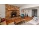 Living room with stone fireplace, hardwood floors, and large windows at 28730 Mountain View Rd, Conifer, CO 80433