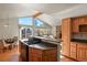 Open kitchen with wood cabinets, island, and views to living room at 28730 Mountain View Rd, Conifer, CO 80433