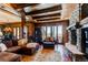 Spacious living room with stone fireplace and scenic views at 5764 Amber Ridge Dr, Castle Pines, CO 80108