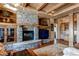 Gathering room with a stone fireplace, built-in shelving, and a large TV at 5764 Amber Ridge Dr, Castle Pines, CO 80108