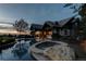 Luxury backyard with pool, spa, and mountain views at dusk at 5764 Amber Ridge Dr, Castle Pines, CO 80108