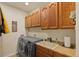 Bright laundry room features washer, dryer, cabinets, and utility sink at 17027 Pale Anemone St, Parker, CO 80134