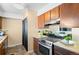 Kitchen features stainless steel appliances and wood cabinets at 1290 S Troy St, Aurora, CO 80012