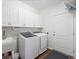 Laundry room with washer, dryer, and ample cabinet space at 14189 St Paul St, Thornton, CO 80602