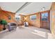 Relaxing basement sitting area with wood-paneled walls and a large window at 12801 Monroe St, Thornton, CO 80241