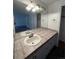 Clean bathroom with single sink vanity, tiled countertop, and large mirror at 2721 S Salida Way, Aurora, CO 80013