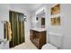 Clean bathroom with brown vanity and green shower curtain at 7131 Clay St, Westminster, CO 80030