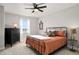 Bedroom featuring an orange bedspread, black dresser, and ceiling fan at 1823 Salers Way, Erie, CO 80516