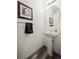 Clean powder room with pedestal sink and circular mirror at 5901 W Lehigh Ave # 9, Denver, CO 80235