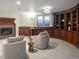 Basement sitting area with built-in curved shelving and fireplace at 385 Baxter Farm Ln, Erie, CO 80516