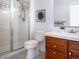 Bathroom with shower, toilet, vanity, and wood cabinets at 385 Baxter Farm Ln, Erie, CO 80516