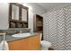 Clean bathroom with granite vanity, wood cabinet, and a gray chevron shower curtain at 2103 Coronado N. Pkwy # D, Denver, CO 80229