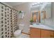 Bathroom with shower/tub, wood vanity, and geometric shower curtain at 8865 Meade Ct, Westminster, CO 80031