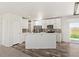 Open kitchen with white cabinets, marble countertops, and a breakfast bar at 165 S County Road 197, Byers, CO 80103