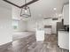 Open kitchen with white cabinets, island, and stainless steel appliances at 165 S County Road 197, Byers, CO 80103