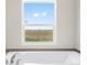 Relaxing bathroom with soaking tub and large window with scenic view at 165 S County Road 197, Byers, CO 80103