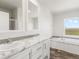 Elegant bathroom with double vanity, marble countertops, and soaking tub at 165 S County Road 197, Byers, CO 80103