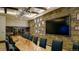 Elegant dining room with stone wall, large TV, and live-edge table at 3015 Newfound Lake Rd, Berthoud, CO 80513