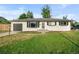 Ranch style home exterior with white brick, dark gray garage door and landscaping at 2996 S Sheridan Blvd, Denver, CO 80227