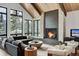Open-concept living room with floor-to-ceiling windows and a cozy fireplace at 72 Dyer Trl, Breckenridge, CO 80424