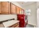Bright laundry room, featuring wood cabinets, a utility sink, and a stackable washer and dryer at 7892 S Country Club Pkwy, Aurora, CO 80016