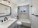Updated bathroom with white vanity, tub and black fixtures at 1059 S Saulsbury St, Lakewood, CO 80226