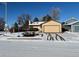 Ranch style home with attached garage and snow-covered yard at 15503 E Princeton Ave, Aurora, CO 80013