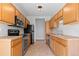 Galley-style kitchen with wood cabinets and stainless steel appliances at 22580 E Ontario Dr # 103, Aurora, CO 80016