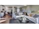 Bright living room with hardwood floors, white sectional sofa and a view of the kitchen at 1230 Sugarloaf Ln, Erie, CO 80516