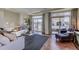 Spacious living room with hardwood floors, large windows, and access to a balcony at 1230 Sugarloaf Ln, Erie, CO 80516
