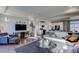 Open living room featuring hardwood floors, comfy sectional sofa, and a view into the kitchen at 1230 Sugarloaf Ln, Erie, CO 80516